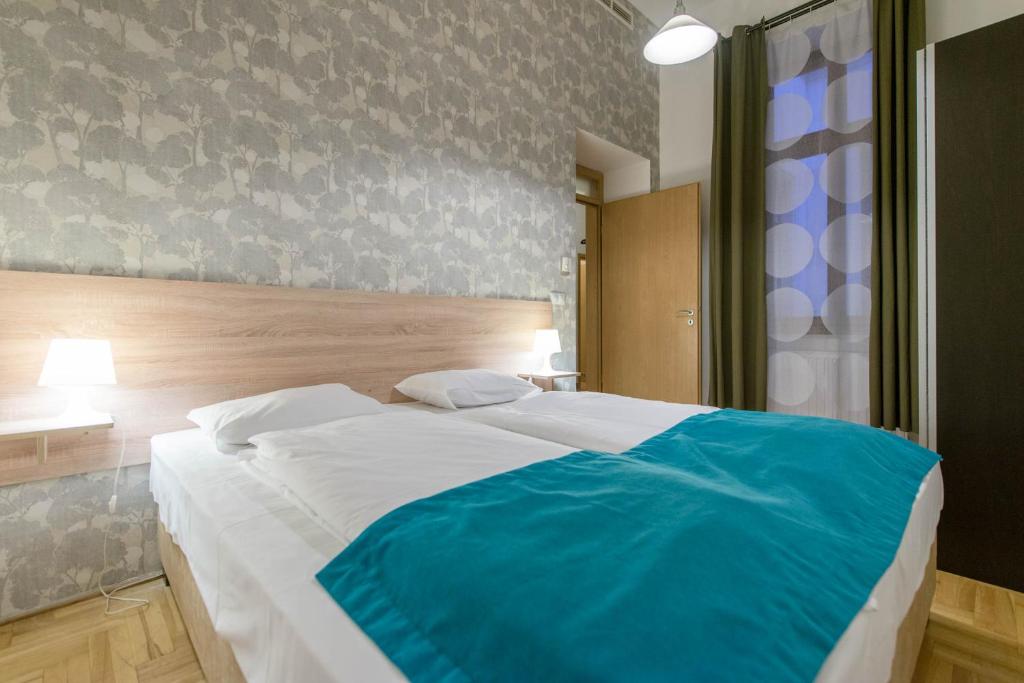 布达佩斯Mango Apartments的一间卧室配有一张带蓝色毯子的大床