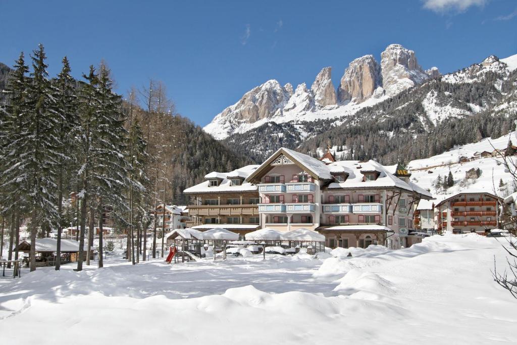 坎皮泰洛迪法萨Hotel Diamant Park的山间滑雪小屋,地面上积雪