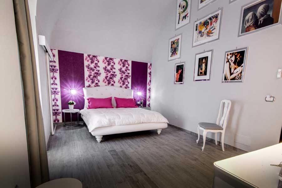 巴列塔Marco Polo B&B的卧室配有白色的床和紫色的墙壁