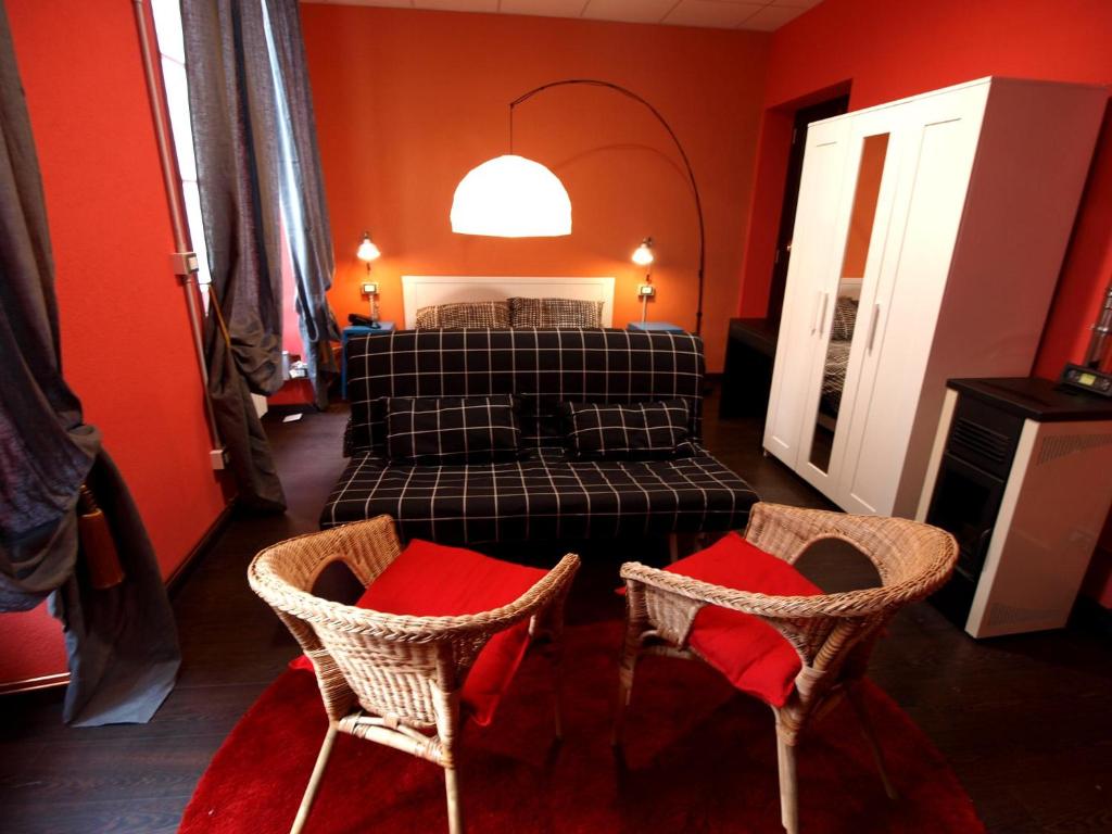 圣雷莫Andres Guest house Sanremo的一间卧室配有一张床和两把椅子