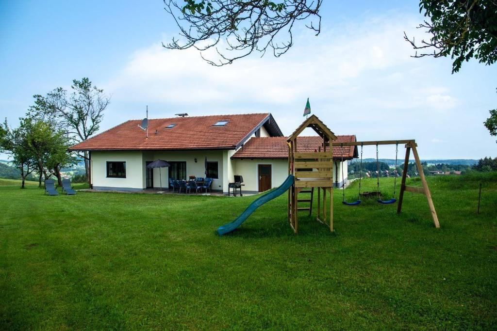 希格斯多夫Ferienhaus für 8 Personen ca 150 qm in Siegsdorf-Vorauf, Bayern Oberbayern的房屋前带滑梯的游乐场