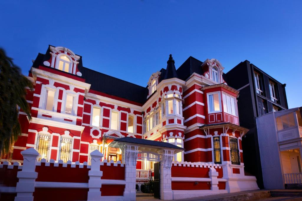 瓦尔帕莱索阿斯托雷卡宫酒店的黑色屋顶的大型红色建筑