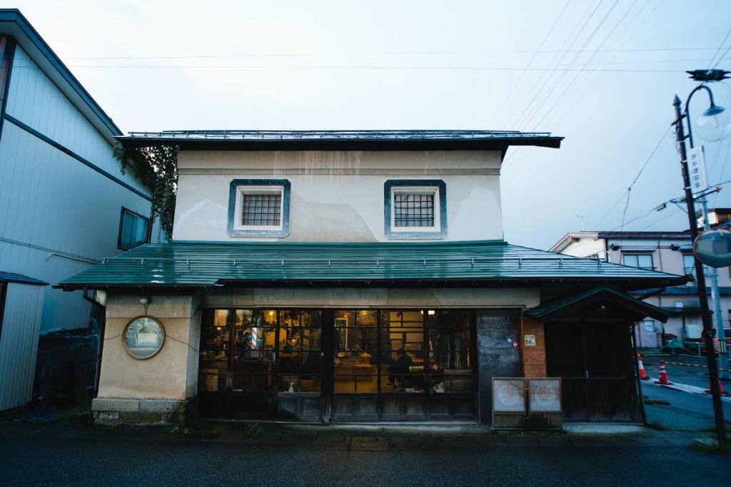 横手市CAMOSIBA旅馆及酒吧的前面有商店的建筑