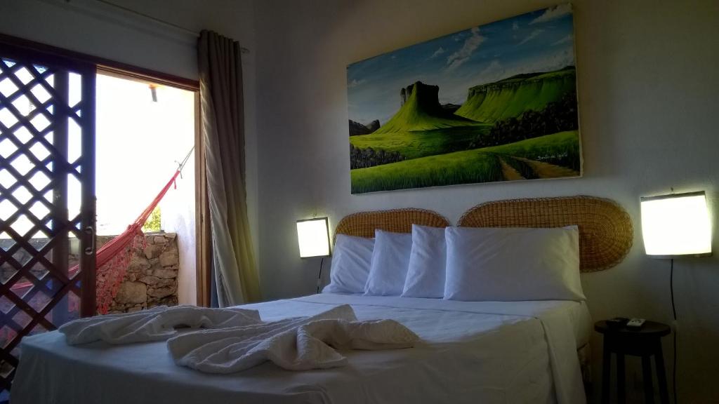 伊加图Art Hotel Cristal de Igatu的一间卧室配有一张带白色床单的床和一扇窗户。