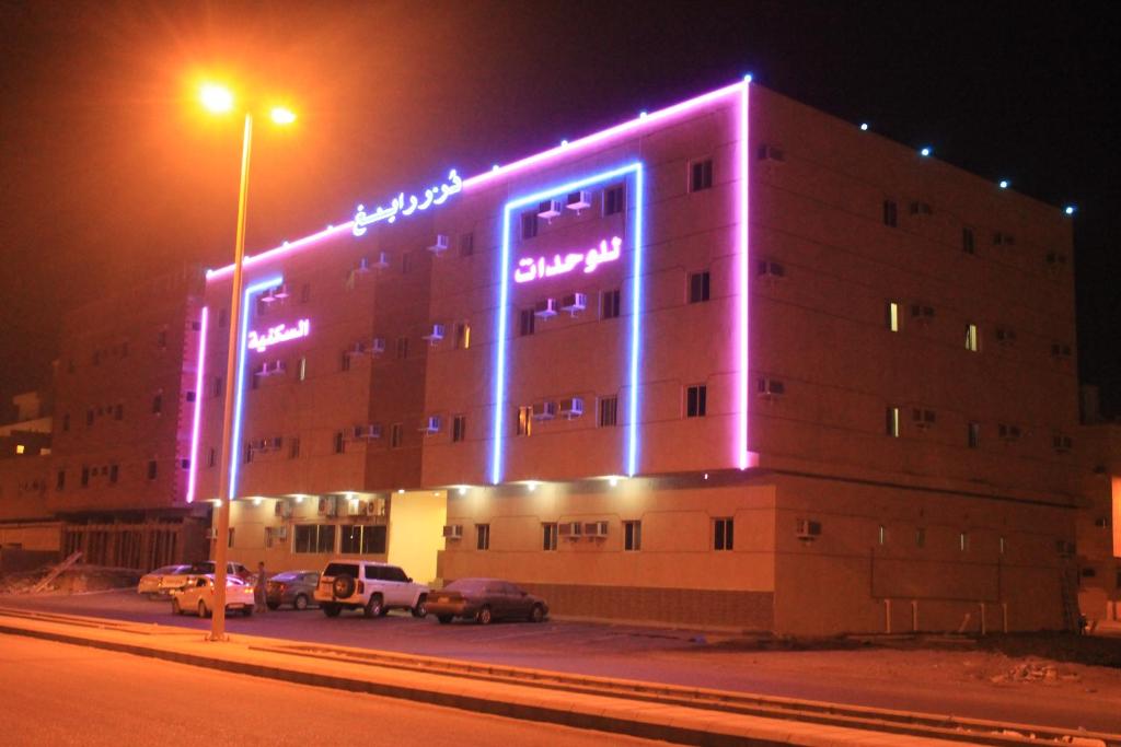 拉比格Dorar Rabigh Complex Residential Units的建筑的侧面有紫色的灯