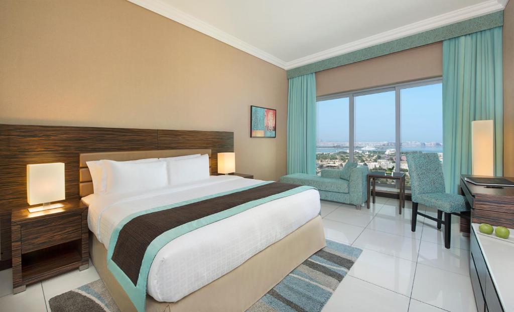 迪拜阿塔纳酒店的酒店客房 - 带一张床和用餐室