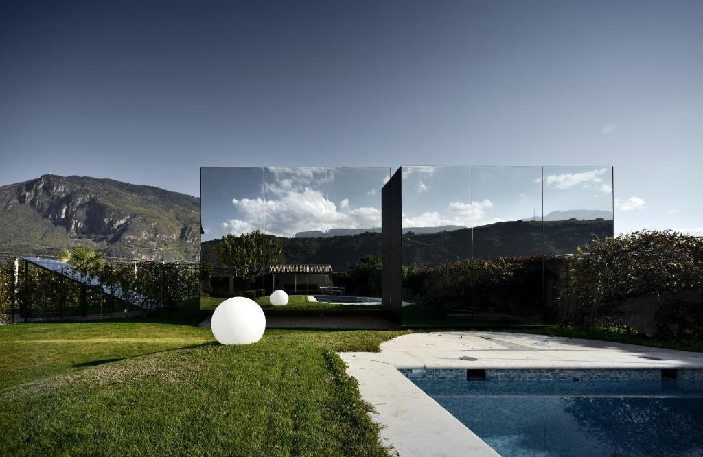 博尔扎诺镜子房屋的草丛中带游泳池的房子