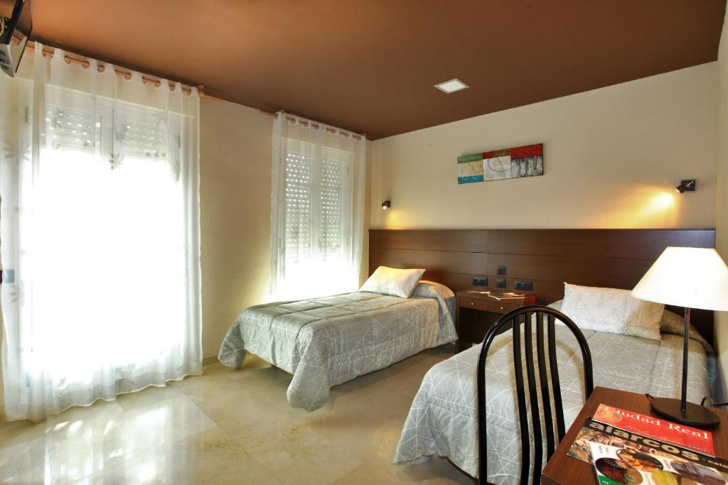 雷阿尔城纳瓦罗酒店 的一间卧室设有两张床和窗户。