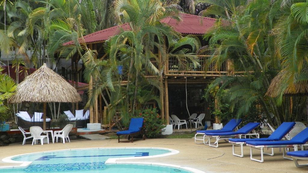 梅尔加Amanwana Ecofinca的一个带蓝色椅子和游泳池的度假村