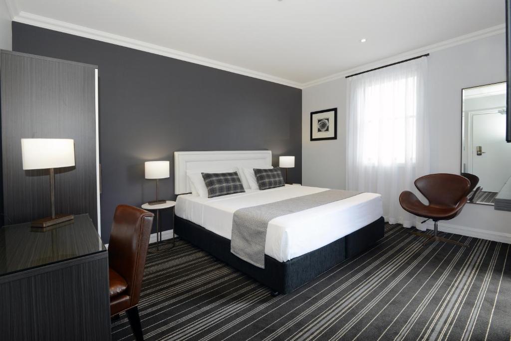 悉尼Perouse Randwick by Sydney Lodges的一间卧室配有一张床、一张桌子和一把椅子