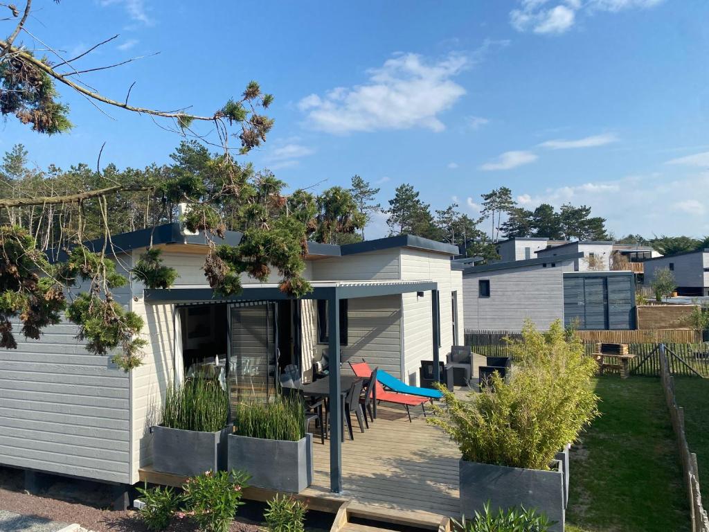 瑞卢维尔莱潘Cottage chalet standing gîte l'Edune résidence de vacances location wifi inclus piscine couverte chauffée proche de la plage的房屋设有1个带桌椅的甲板