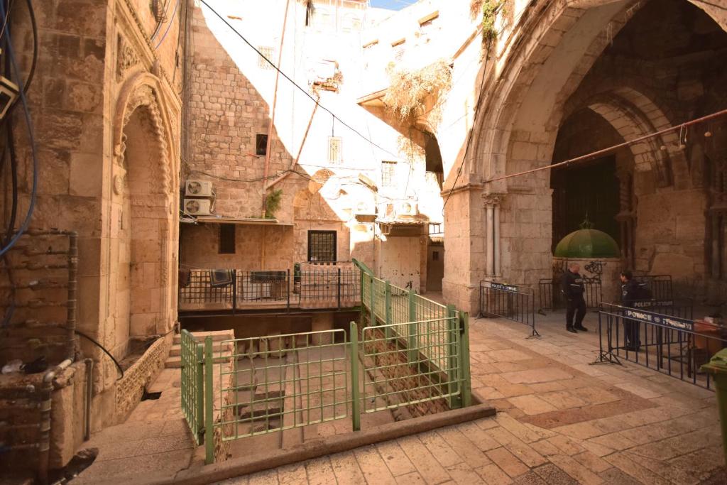 耶路撒冷Bab El-Silsileh Hostel的建筑物中的一条小巷,有人在里面走