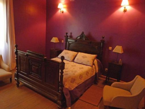 拉德拉达玛丽亚别墅旅馆的一间卧室配有一张床和紫色的墙壁