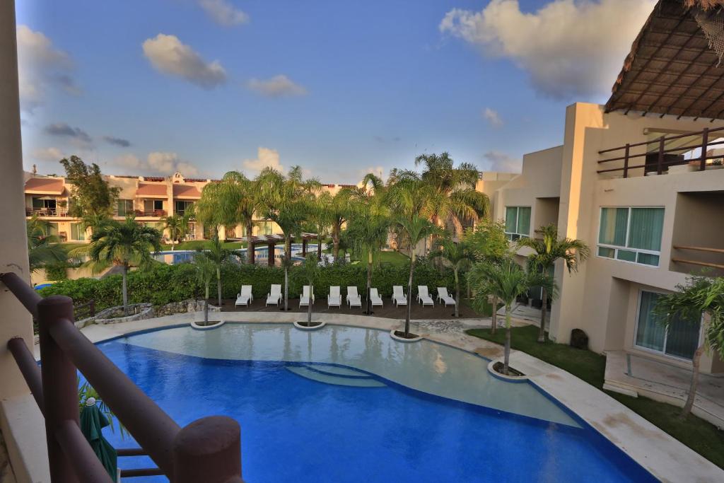 阿文图拉斯港Coral Maya Stay Suites的享有带椅子的游泳池和大楼的景色