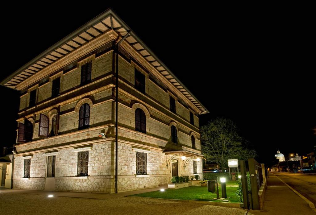 阿西西拉斐尔公园别墅酒店的一座古老的砖砌建筑,晚上有灯