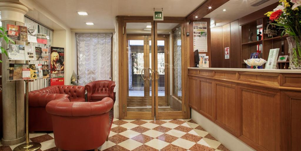 威尼斯佩里格里诺商业酒店的一间设有真皮座椅和酒吧的等候室