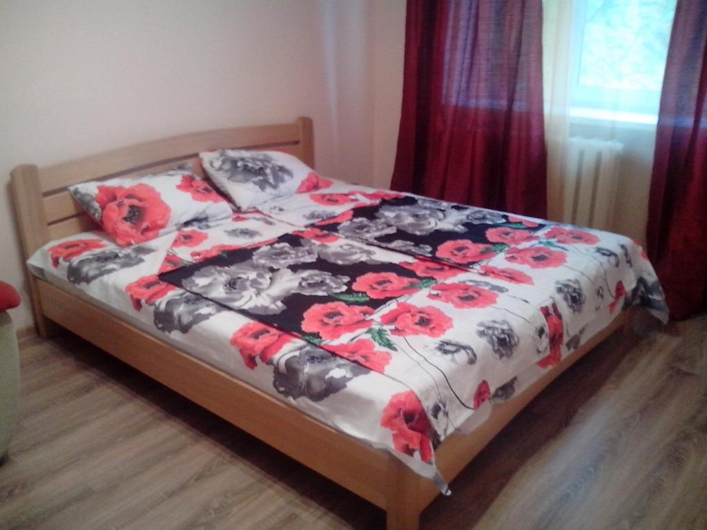 基辅Apartment Syrec的一间卧室配有一张带花卉棉被的床