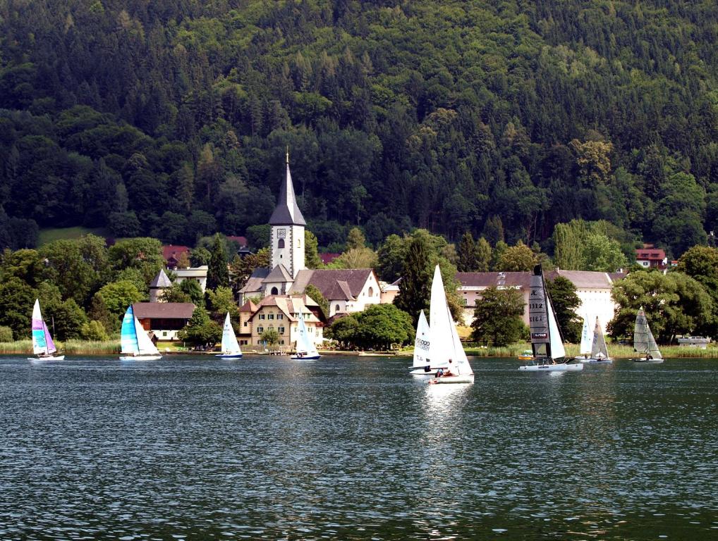 博登斯多夫Ferienwohnungen Steger的一群在湖上带教堂的帆船