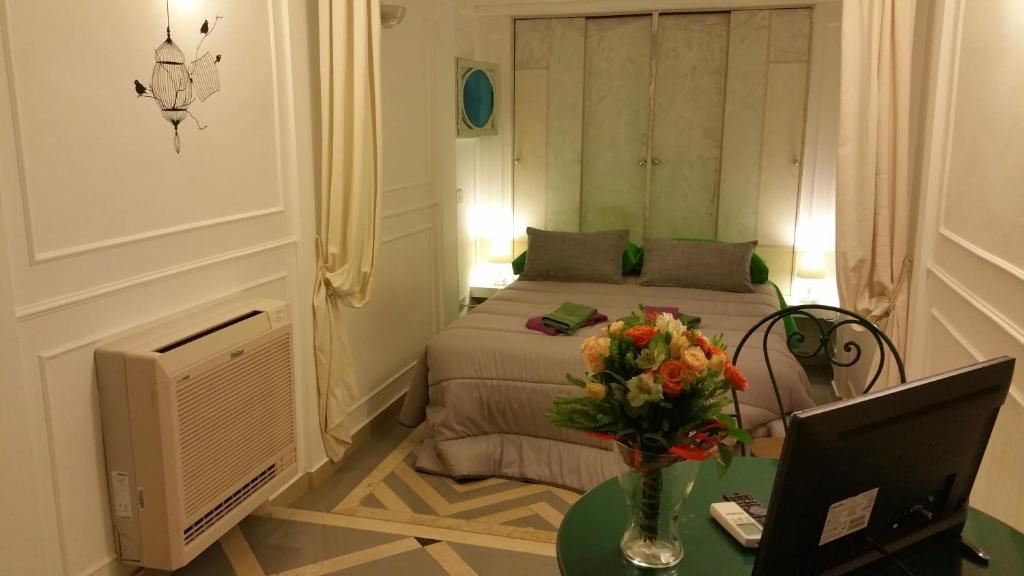 巴里Suite Calefati "Monolocale"的一间卧室配有一张床和一张花瓶桌子