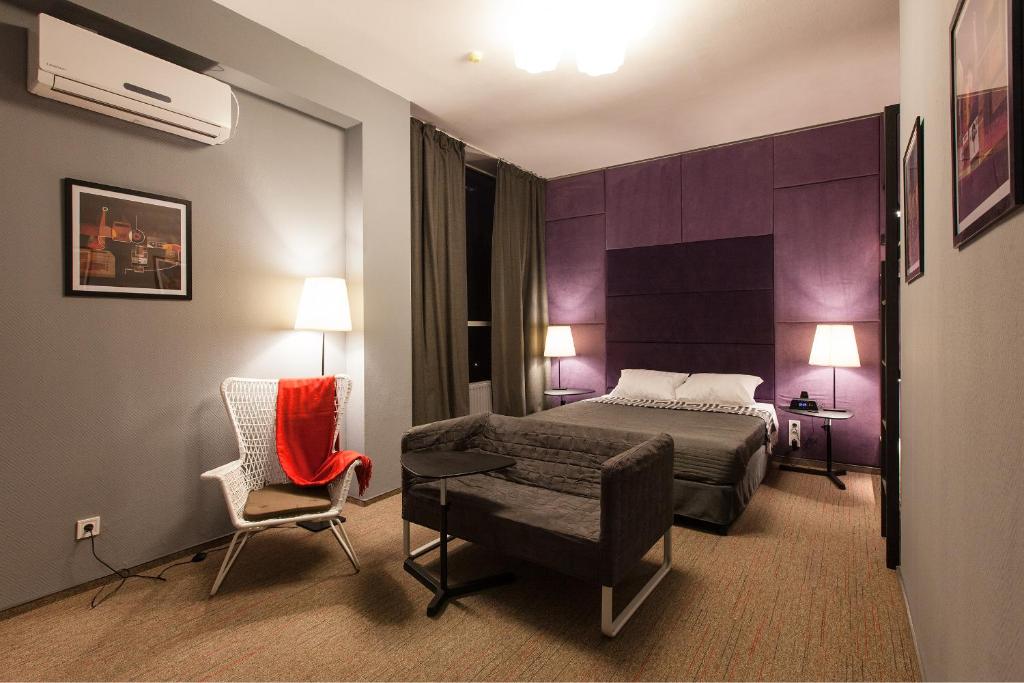 第聂伯罗纽波特酒店的配有一张床和一把椅子的酒店客房