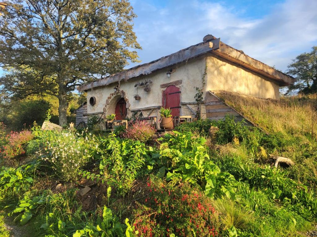 Saint-Sulpice-les-FeuillesLa maison Sacquet et son bain nordique的一座带花园的小山上的古老房屋