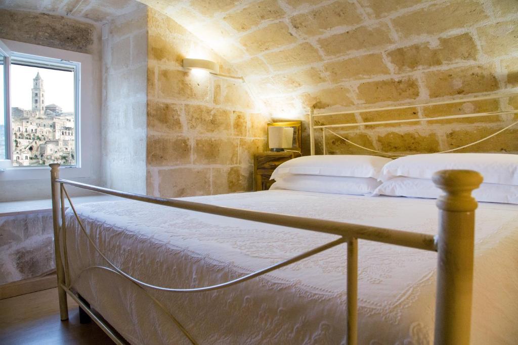 马泰拉卡萨维多利亚度假屋的石墙房间内的一张床位