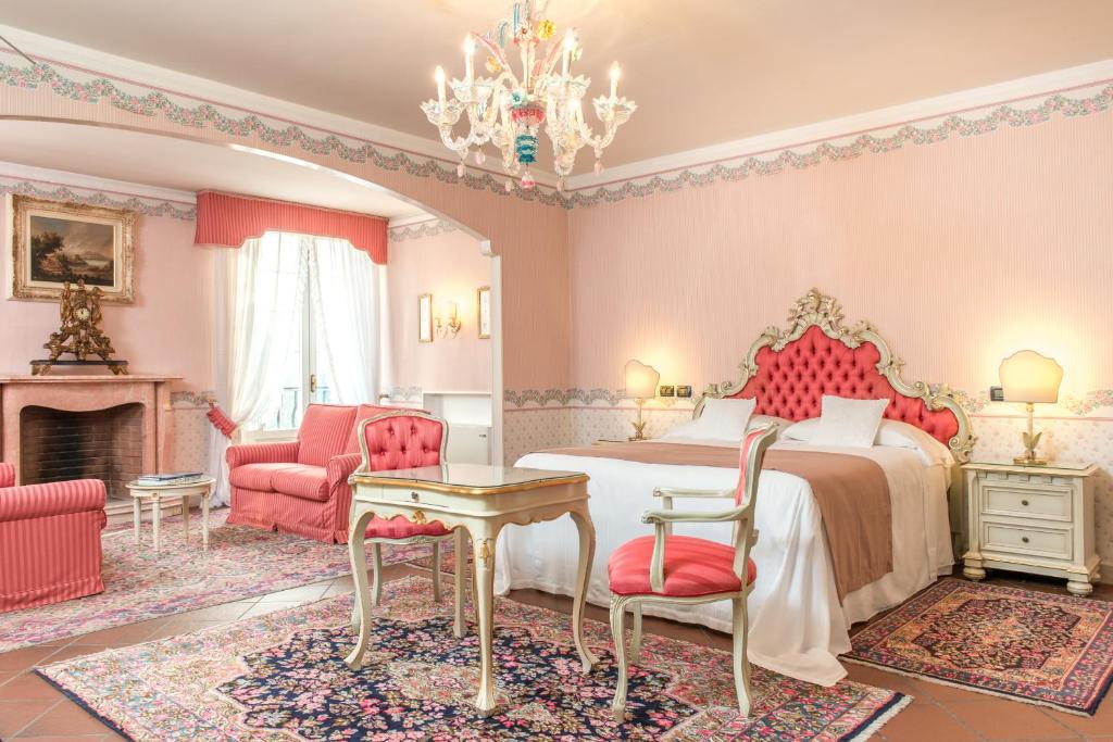 费拉拉Duchessa Isabella Collection by Uappala Hotels的一间卧室配有一张床和一个壁炉