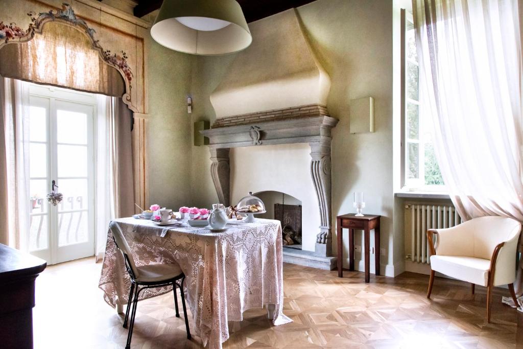 贝加莫B&B Dimora Delle Donnole Bergamo Alta的一间带桌子和壁炉的用餐室