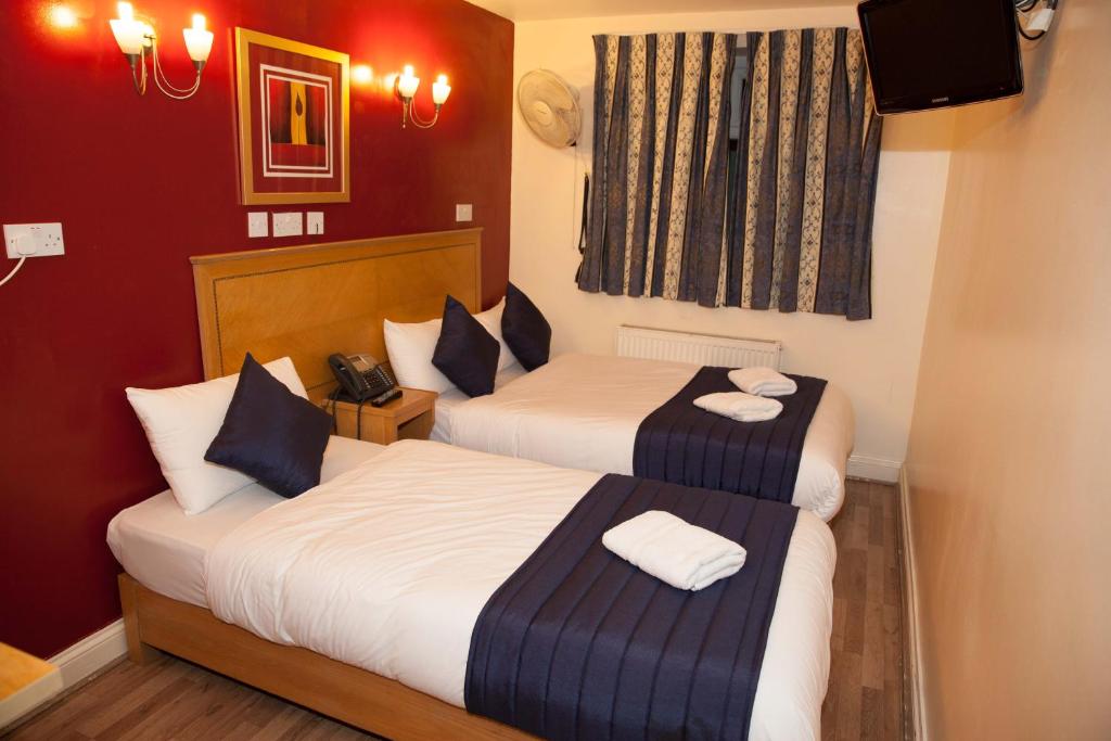 伦敦圣马克酒店的红色墙壁的酒店客房内的两张床