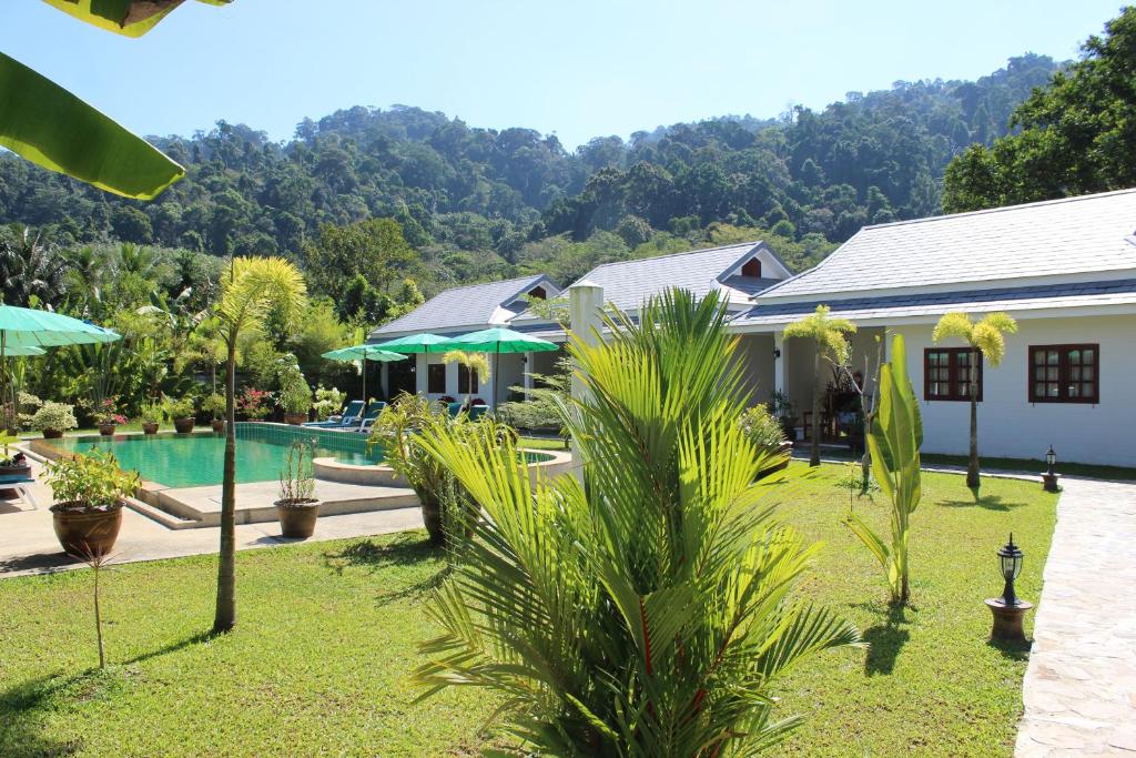 蔻立Villa Colina Khao Lak Rooms and Bungalows - Adults Only的一座带游泳池和度假村的别墅