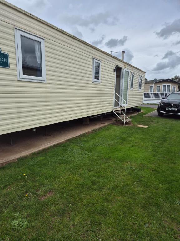 Dawlish WarrenJ06 Warren Retreat的移动房屋旁边设有停车位