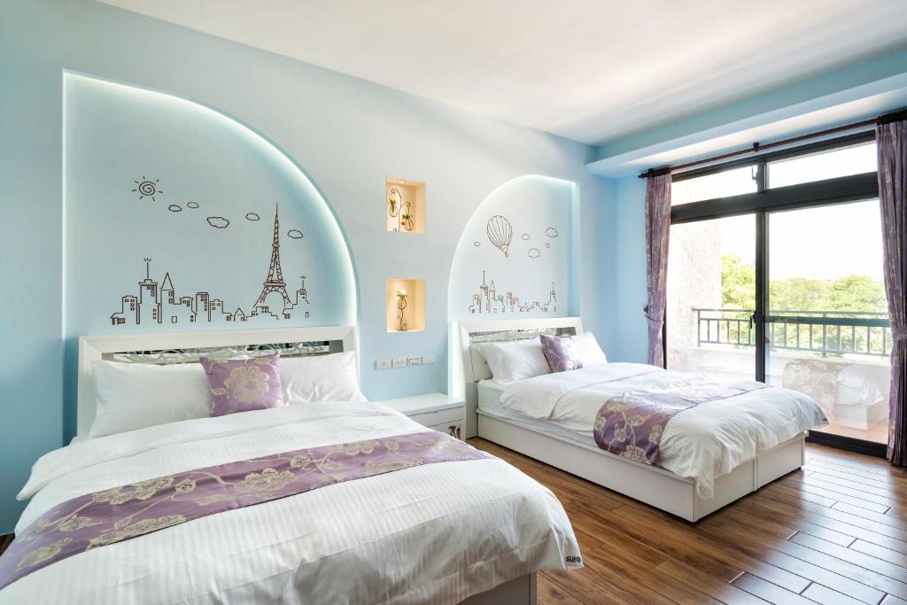 花莲市好趣淘休閒民宿 電梯 車位預約制的卧室设有两张床,拥有蓝色的墙壁和窗户。