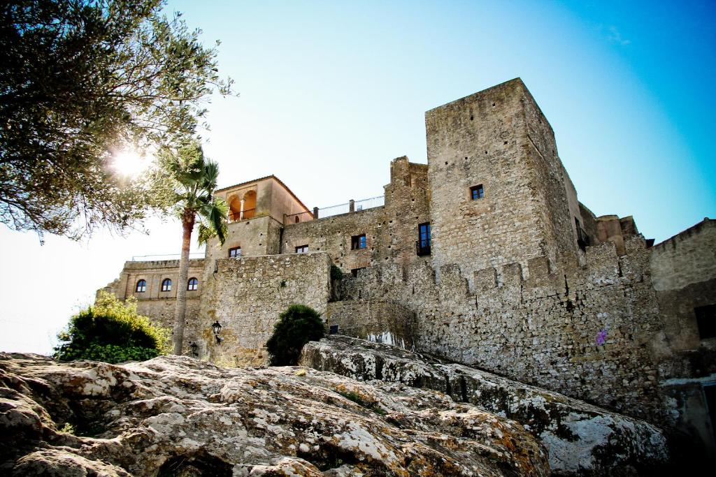弗龙特拉堡Hotel Tugasa Castillo de Castellar的一座古老的城堡,前面有棵树