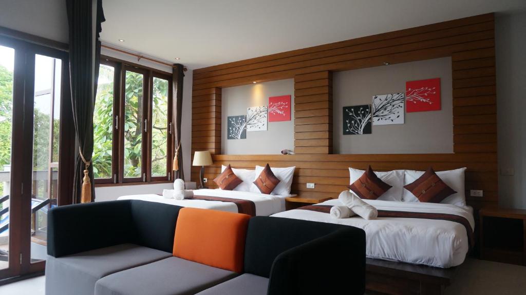 高兰Lanta Intanin Resort - SHA Extra Plus的酒店客房,设有两张床和一张沙发