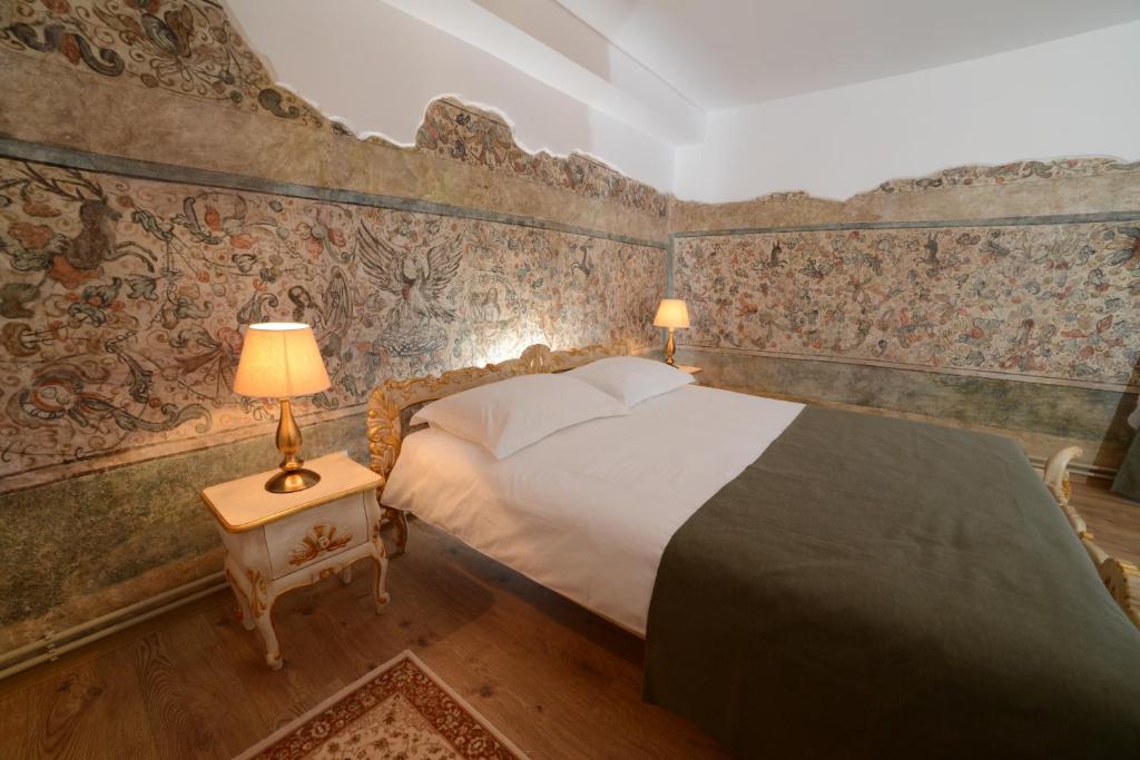 锡比乌阿斯特诺姆民宿的壁纸客房内的一间卧室配有一张床