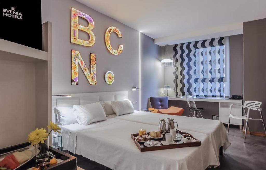 巴塞罗那埃文尼亚罗塞里奥酒店的一间卧室配有一张床,上面放着一个食物托盘
