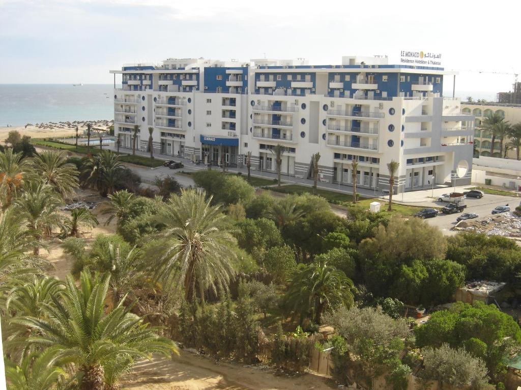 苏塞乐摩纳哥酒店和海水浴的一座棕榈树和海洋的白色大建筑