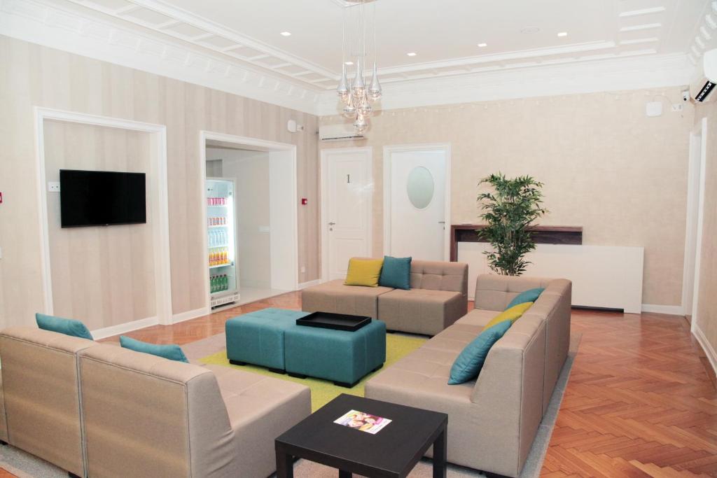 贝尔格莱德卡拉旺旅馆的客厅配有两张沙发和一台电视机