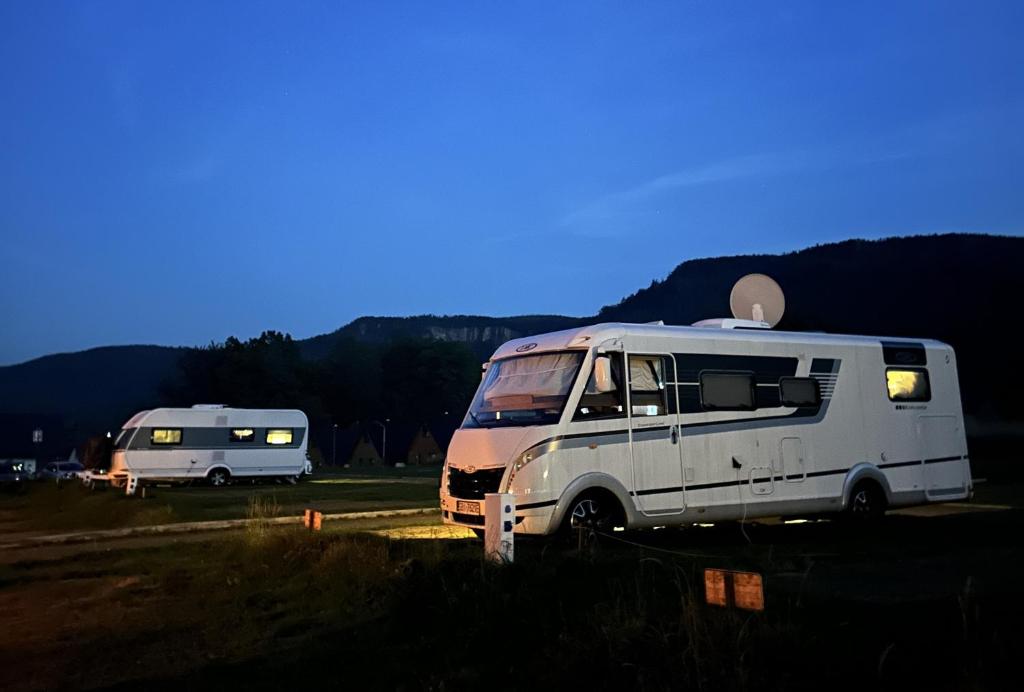 拉德库夫Góry Stołowe Camp -miejsce na kamper, przyczepę lub namiot的两个rvs在一块场地上彼此相邻