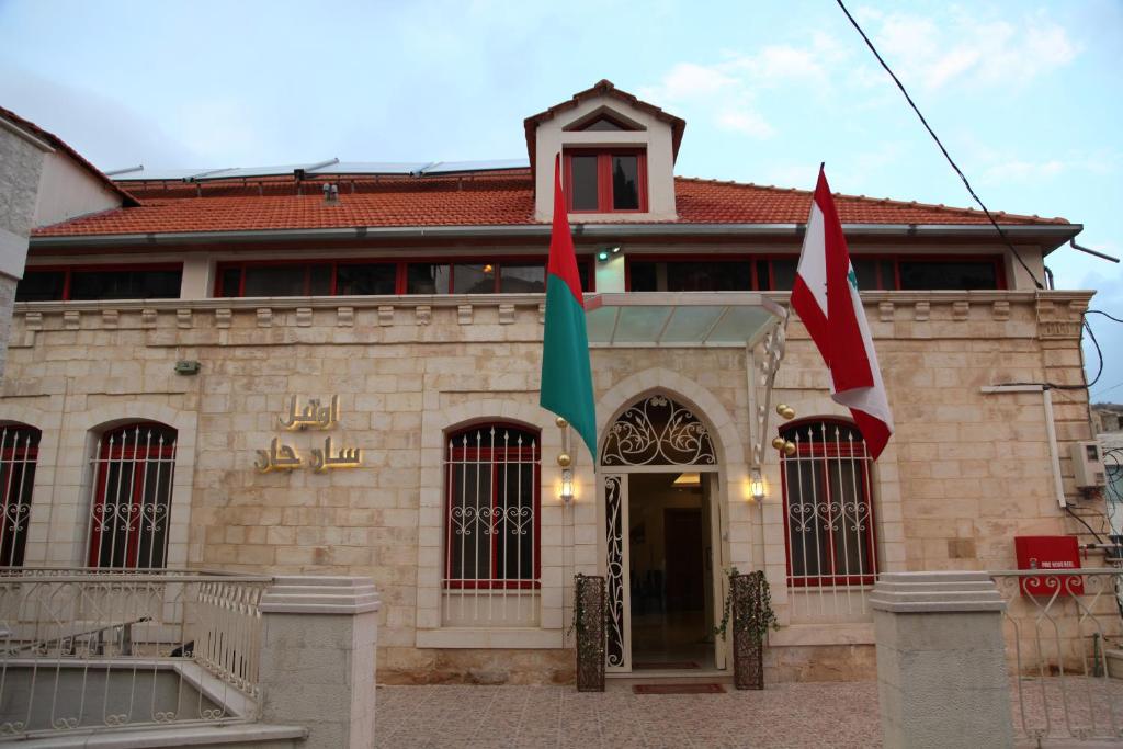 扎赫勒圣约翰酒店的前面有两面旗帜的建筑