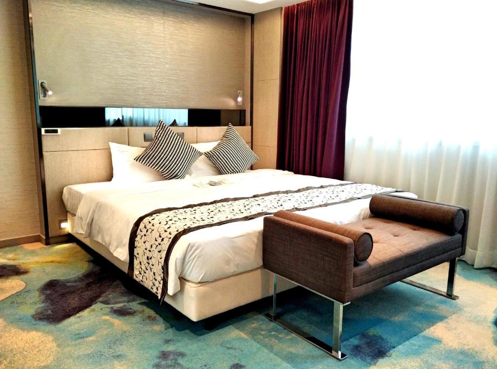 香港尚豪酒店的一间卧室配有一张大床和一把椅子