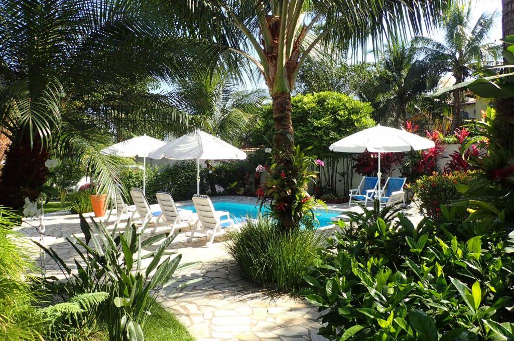 帕拉蒂Maris Paraty的一个带椅子和遮阳伞的游泳池和一个游泳池