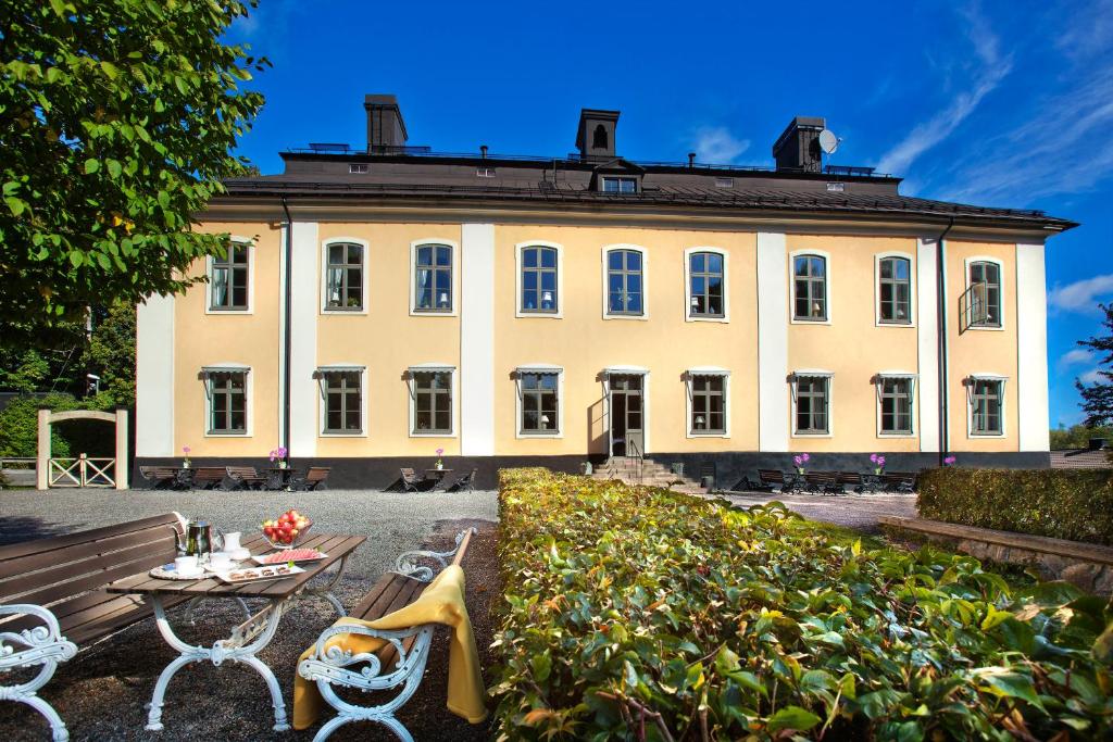 斯德哥尔摩阿克斯霍夫斯洛特酒店的一座大建筑前面设有桌椅