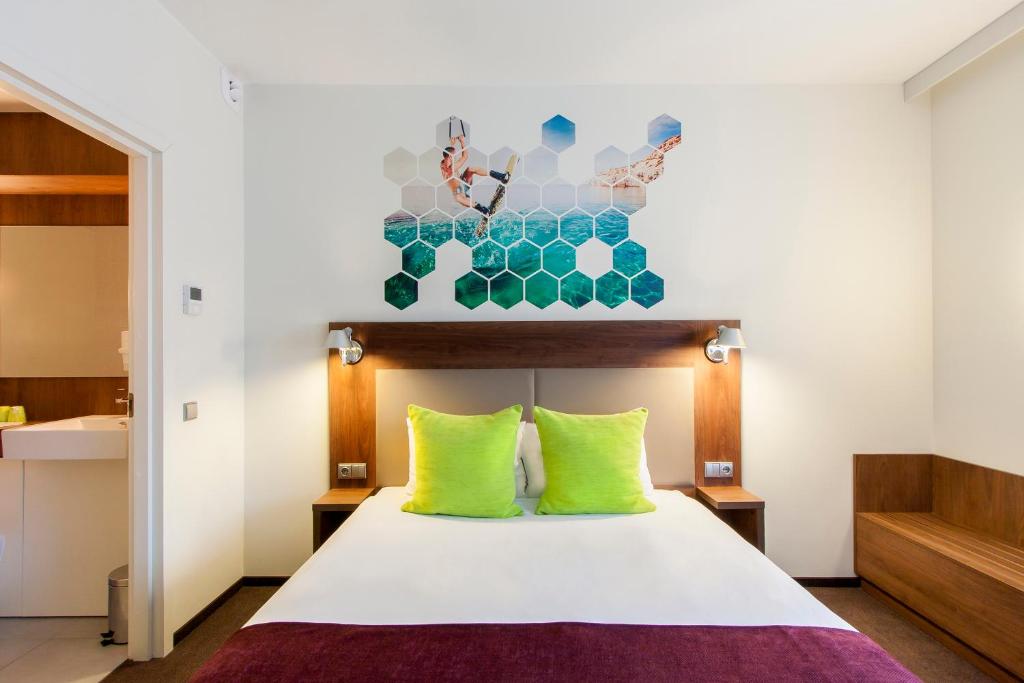 维尔纽斯维尔纽斯宜必思尚品酒店的一间卧室配有带石灰绿色枕头的床