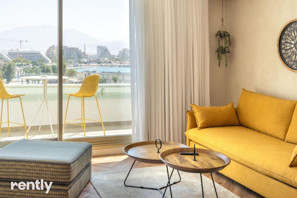埃拉特Luxury Apartments And Studios At Sea Side By Rently的客厅设有黄色的沙发和大窗户