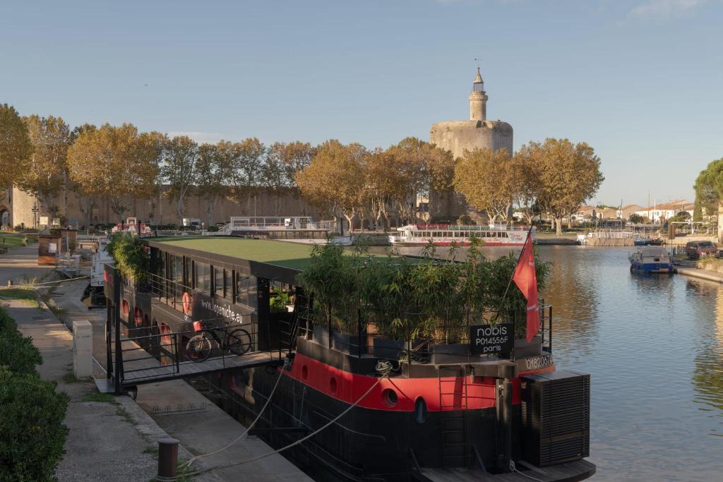 艾格-莫尔特LA PENICHE - Bed And Bicycle - Aigues Mortes的船停靠在河上的码头