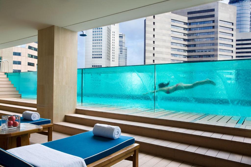 新加坡Ascott Raffles Place Singapore的游泳池中游泳的游泳池