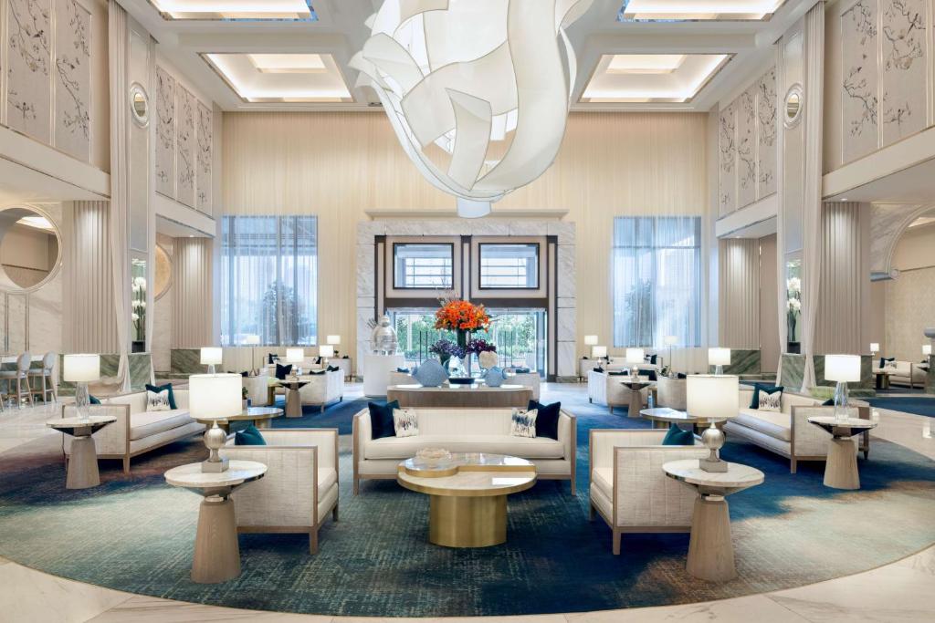 拉斯维加斯Crockfords Las Vegas, LXR Hotels &amp; Resorts at Resorts World的大堂配有沙发、桌子和吊灯