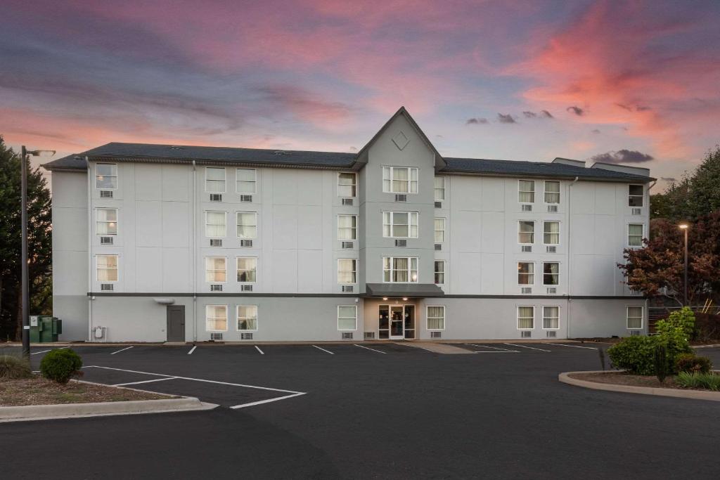 阿什维尔Rodeway Inn & Suites near Outlet Mall - Asheville的一座大型白色建筑,设有停车场