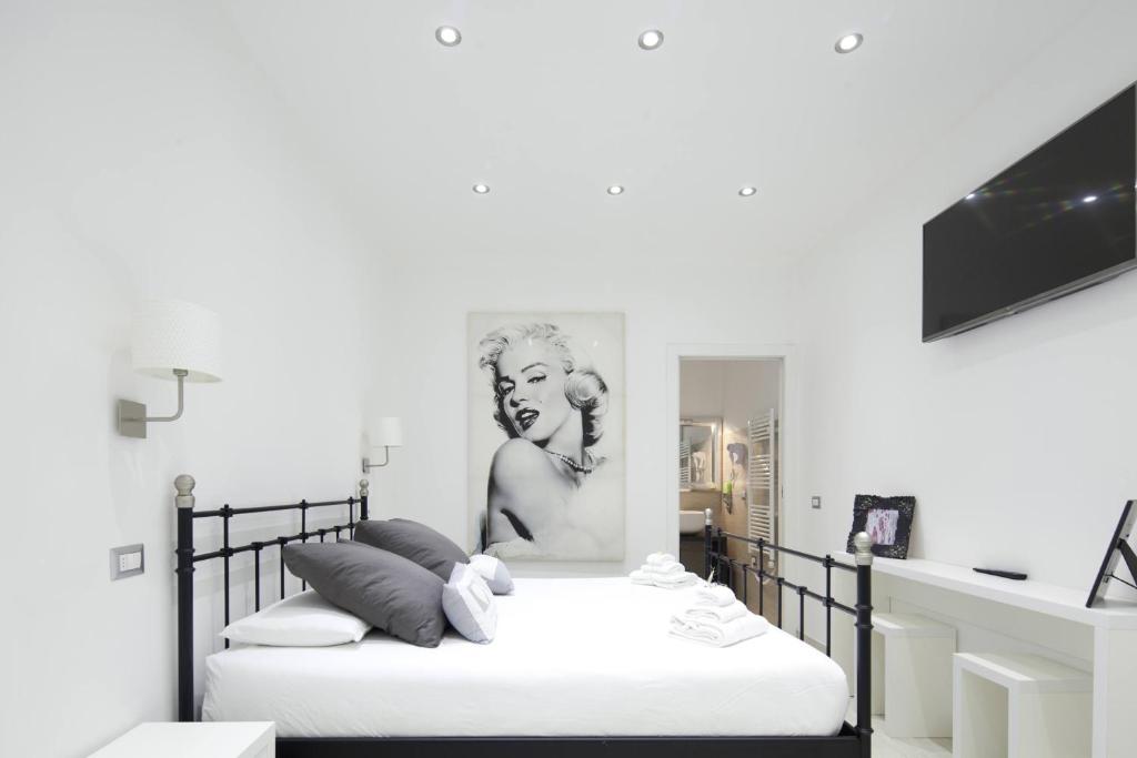 蒙扎阿罗西奥酒店的一间卧室配有两张床,一张女人的照片